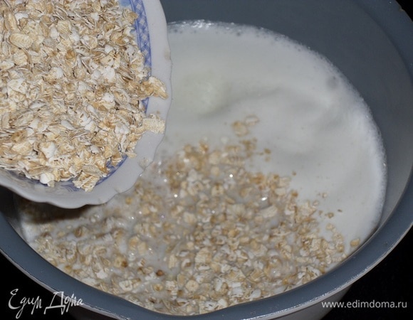 Доводим молоко до кипения и добавляем овсяные хлопья.