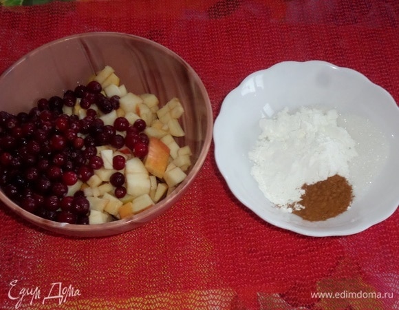 В другую чашку выкладываем нарезанные яблоки и клюкву.