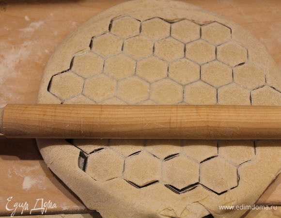 Затем сверху кладем второй пласт теста и скалкой быстро раскатываем. Переворачиваем форму, вынимаем пельмени.