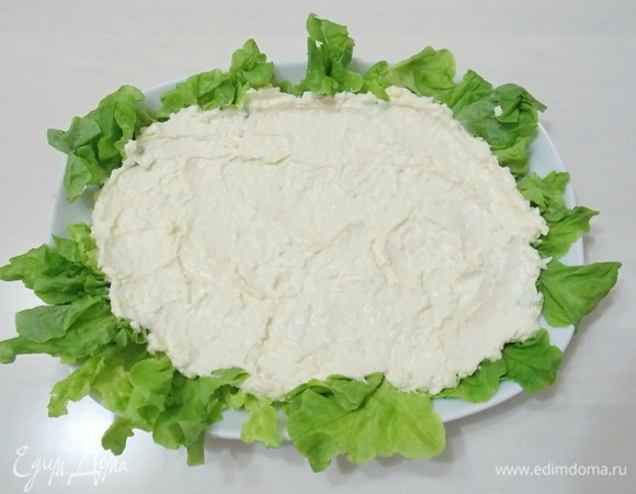 Кладем массу на блюдо с салатом и разравниваем.