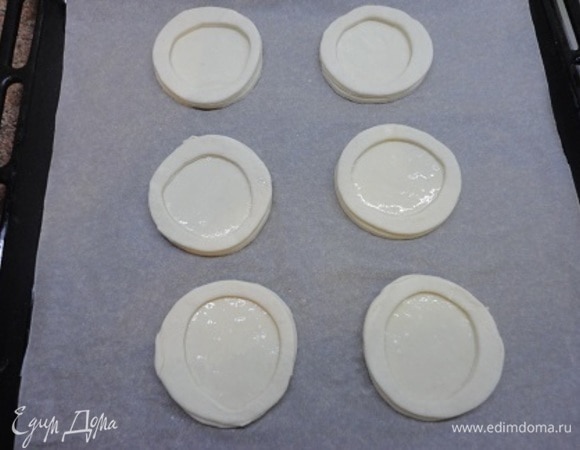 Из теста вырезать круглые лепешки примерно 10 см в диаметре (или меньше). Равное число. Из половины лепешек вырезать кружки меньшего диаметра, чтобы получились кольца. Лепешки смазать слегка взбитым яйцом (осторожно, чтобы яйцо не стекло по бокам, иначе тесто склеится и не расслоится). Уложить кольца и тоже смазать их яйцом. Выпекать 10–15 минут при температуре 200°C.