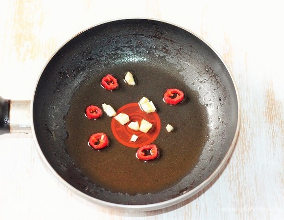 Приготовим медовый соус. На разогретом масле обжариваем порубленный чеснок и нарезанный колечками перец чили до появления аромата. Удаляем овощи из сковороды, масло оставляем.