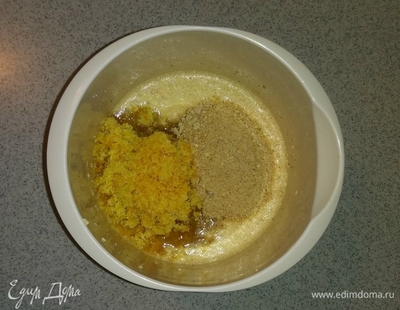 Затем к смеси куриных яиц и сливочного масла добавляем измельченные мюсли, измельченные апельсиновые цукаты с сахарным песком, пряничные специи, мед, коньяк и перемешиваем все миксером до однородного состояния.