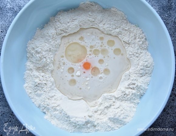 Для белого теста просеять в миску муку, сделать в центре углубление, куда влить воду, добавить уксус столовый, растительное масло, соль и яйцо.