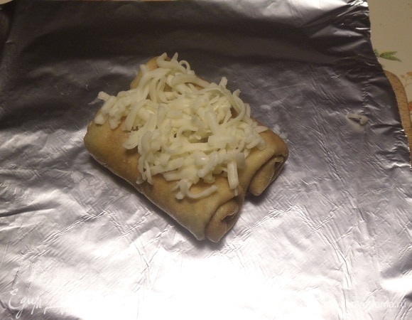 На лист фольги выкладываем 2 начиненных блина и посыпаем сыром. Аналогично делаем еще 3 пары блинов.