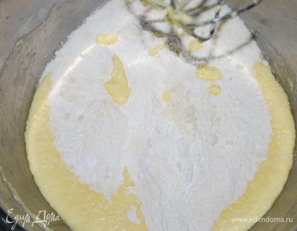 Масло комнатной температуры взбейте с сахаром и по одному добавляйте яйца, каждый раз хорошо перемешивая. Добавьте сверху два вида муки. Хорошо перемешайте.