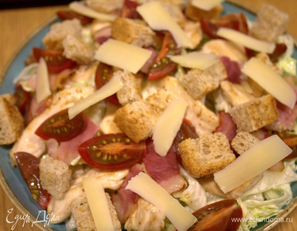 Перенести дольки на блюдо и с помощью овощечистки посыпать слайсами твердого сыра.