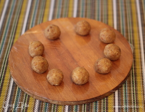 Из обрезков бисквита сделаем снежки для украшения. К обрезкам добавить немножко карамельного соуса, скатать шарики и поместить их в морозилку до полной заморозки. После заморозки шарики обвалять в креме и кокосовой стружке и снова поставить в морозилку на 20 минут.