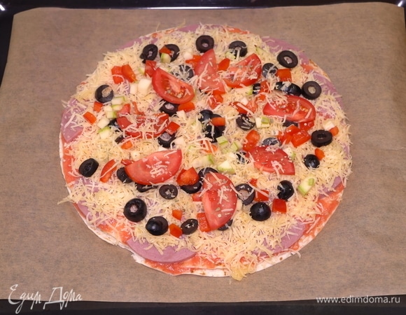 Последний штрих — еще немного сыра, и ставим пиццу в заранее разогретую до 200°C духовку на 20–25 минут.