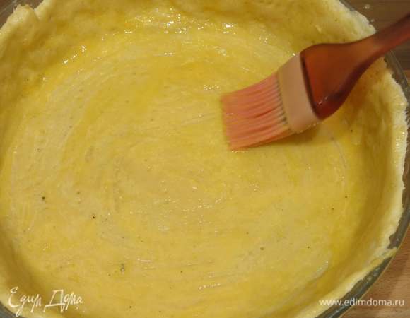 Достаем тесто частично пропеченное, взбиваем яйцо и смазываем тесто.