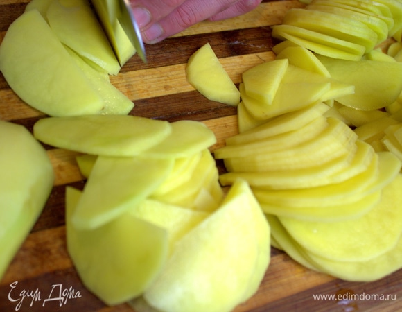 Картофель нарезать пополам и затем — тонкими слайсами.
