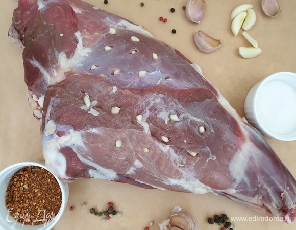 Сделайте неглубокие надрезы по всей поверхности мяса и нашпигуйте его чесноком.