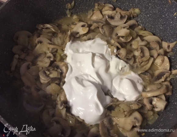 Положить к грибам сметану. Если масса не достаточно жидкая, влить бульон или кипяченую воду. Посолить и поперчить.