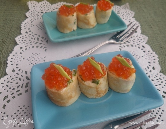 Поверх мини-блинчиков выкладываем икру, украшаем зеленью.