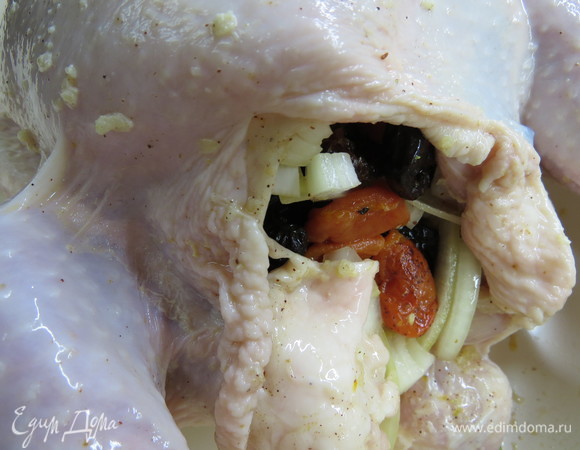 Брюшко курицы фаршируем начинкой из сухофруктов, лука и лимона. Закалываем отверстие зубочистками.