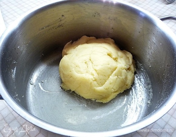 Приготовим тесто для профитролей и основы. В небольшую кастрюльку наливаем воду, добавляем масло и соль, даем закипеть. Всыпаем всю муку, активно мешаем лопаткой и завариваем тесто. Готовое тесто собирается в шар.