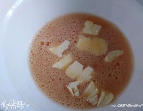 За это время яйца поменяют цвет. Добавить к ним нарезанное кусочками сливочное масло. Влить молоко. Перемешать.