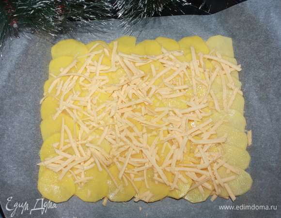 Посыпаем картофель солью и сверху кладем слой сыра (60 г твердого сыра предварительно натереть на крупной терке). Ставим противень в духовку на 30 минут при 180°C.