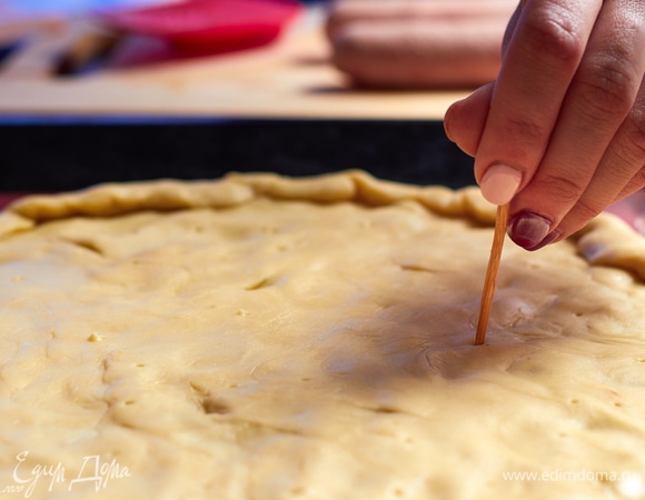 Размороженное тесто распределите по противню, придайте форму, наколите в нескольких местах зубочисткой.