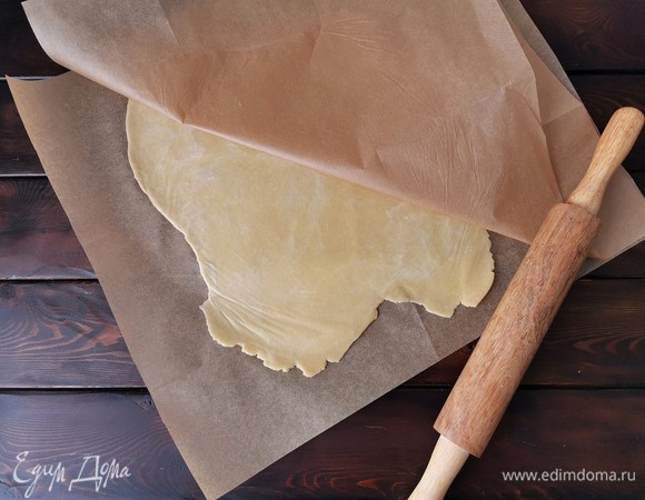 Достаем тесто из холодильника и раскатываем его между двумя листами пергаментной бумаги до толщины 3 мм.