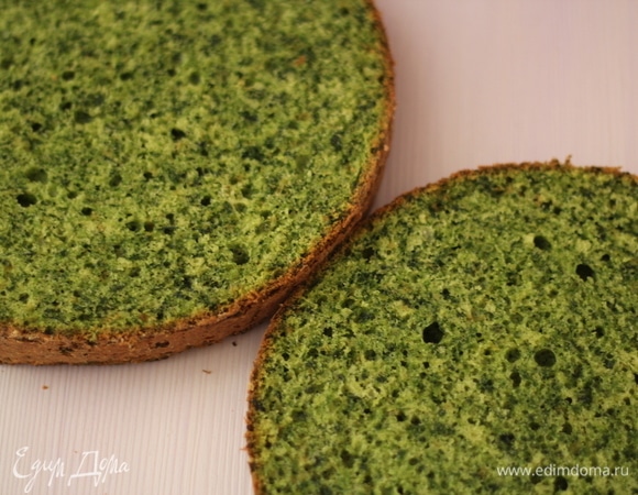 Приготовить продукты. Если шпинат свежий, просто промыть. Я брала замороженный. Предварительно разморозить и отжать лишнюю жидкость через сито. В измельчитель всыпать шпинат и растительное масло, измельчить до однородной консистенции. Отдельно смешать муку и разрыхлитель. Белки отделить от желтков, взбить до состояния пиков, добавить желтки, перемешать миксером. Добавить смесь шпината и масла, перемешать миксером. Добавить муку с разрыхлителем, аккуратно перемешать лопаткой до однородной массы. Тесто вылить в форму (у меня 18 см), предварительно смазанную маслом и обсыпанную мукой. Поставить в разогретую до 180°C духовку, выпекать 30–35 минут. Готовность проверять зубочисткой. Как только сухая — вынуть. Бисквит остудить на решетке. У бисквитного коржа срезать верхушку и донышко, чтобы они не портили яркий зеленый цвет бисквита. Не бойтесь шпината, он нейтрален на вкус и дает такой потрясающий зеленый цвет бисквиту.