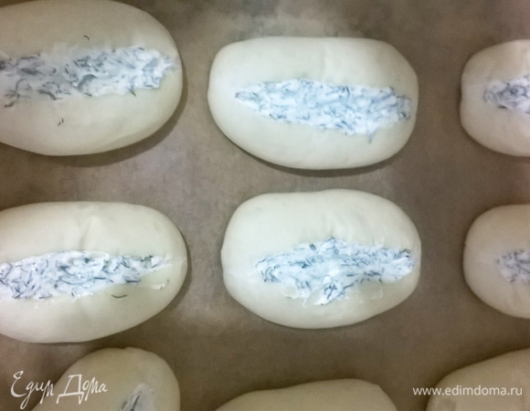 В подошедших булочках острым ножом делаем надрез и кладем туда начинку. Отправляем в духовку выпекаться при 220°C до золотистого цвета.