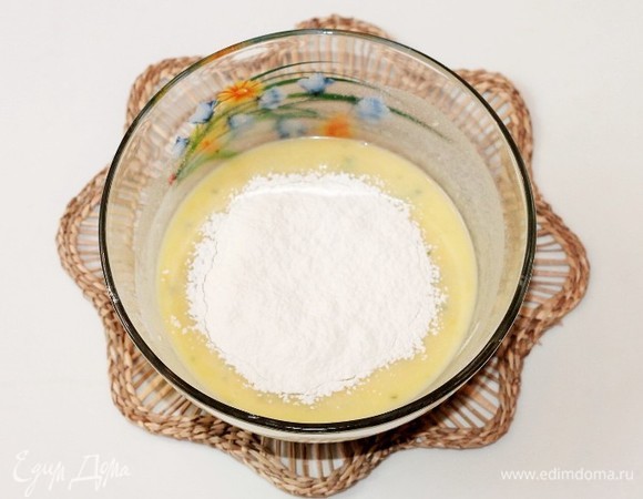 В жидкую смесь небольшими частями добавить мучную смесь, вначале перемешать ложкой, а затем взбить миксером до однородности. Тесто должно быть без комков.