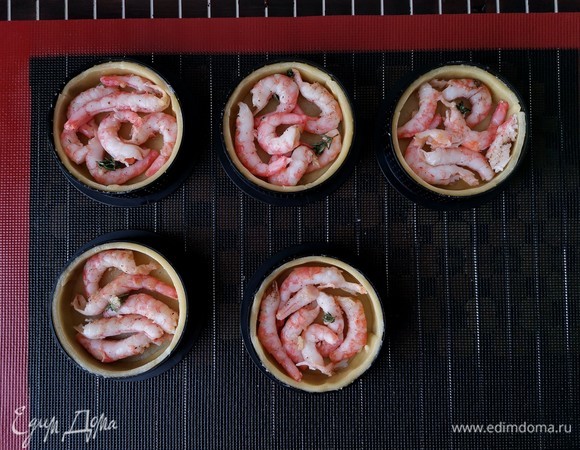 По прошествии 5 минут достаем тарты из духового шкафа и на дно кладем креветки.