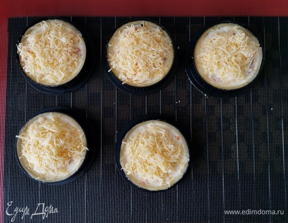 На третьем этапе от души посыпаем тарты натертым сыром. Возвращаем в духовку еще на 25 минут.