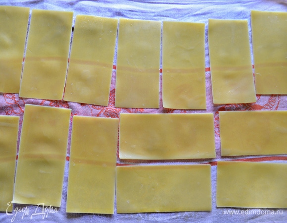 Листы лазаньи, если того требует инструкция на упаковке, предварительно отварить в подсоленной воде с добавлением 1 ст. л. оливкового масла, чтобы листы не склеивались между собой. Затем выложить листы теста на льняное полотенце для остывания.