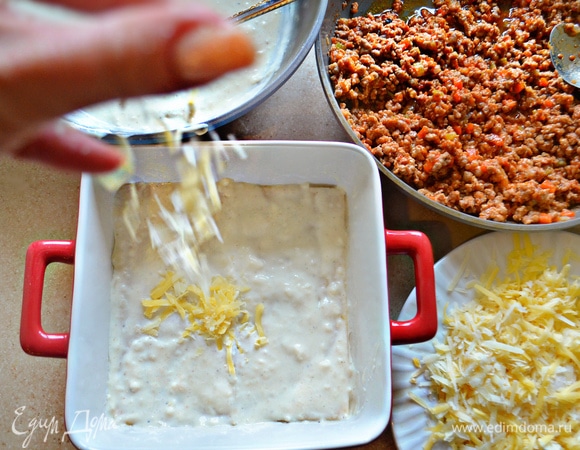 Форму для запекания смазать оливковым маслом, немного выложите соус бешамель. Уложите один слой листов лазаньи, затем — слой бешамель, далее — слой соуса болоньезе и посыпьте сыром.