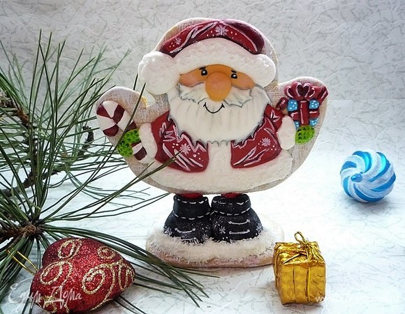 Теперь ставим нашего дедулю на ножки. Для этого вставляем назад шпажки, ставим их на середину подставки и где встала шпажка, там рисуем карандашом точку, так же намечаем основу для башмачков. Аккуратно с помощью шила делаем насквозь отверстия в башмачках и подставке. Далее продеваем шпажки с дедулей в башмачки, смазываем донышки башмачков и подставку, где они будут крепиться айсингом, и ставим пряник на подставку, продевая шпажки насквозь и приклеиваем на айсинг. Все, наш пряник уверенно стоит на подставочке.