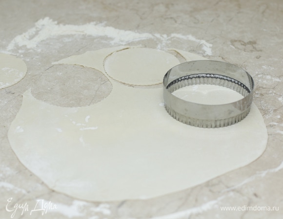 Разделите отдохнувшее тесто на 3–4 части, каждую раскатайте в тонкий сочень. С помощью тарелки или специальных формочек вырежьте небольшие кружочки. Я предпочитаю маленькие чебуреки, поэтому использую небольшую формочку для нарезки теста.