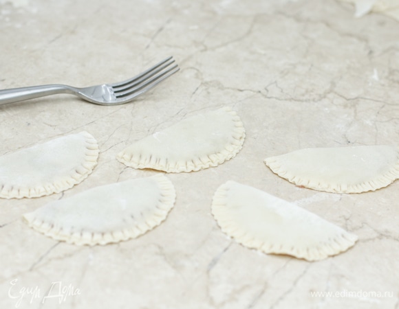 Сложите чебуреки в виде полумесяца, придавите края вилкой.