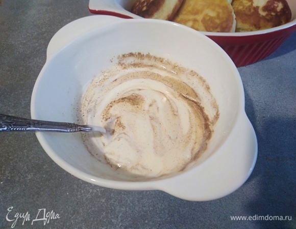 Духовку разогреть до 160°C. Смешать все для заливки. Вместо корицы можно взять ваниль или вообще не добавлять специи. Налить по ложке заливки на каждый сырник и поставить в духовку. Запекать 15 минут.