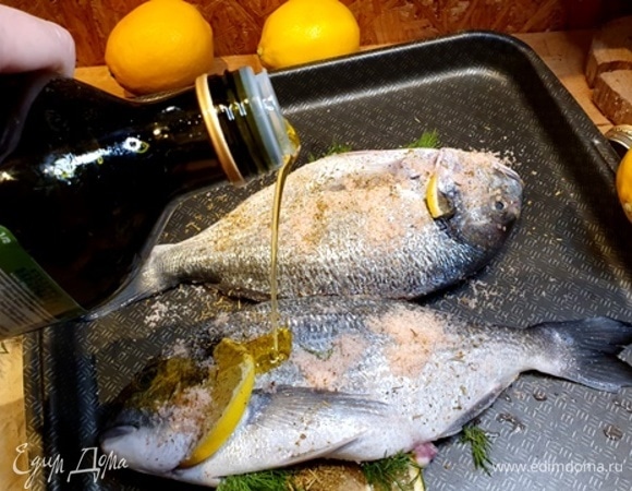 Поливаем сверху оливковым маслом. Можно обработать маслом всю рыбу, со всех сторон.