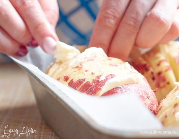 Вложите кусочки масла между гребешками картошки. Примерно через каждые три ломтика.