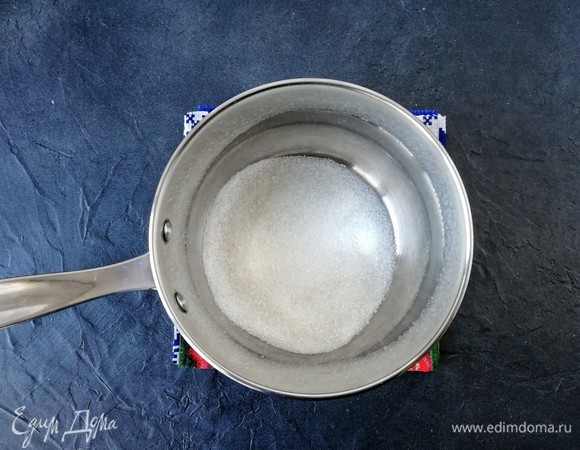 В чистый и сухой сотейник с толстым дном высыпаем сахар и ставим его на плиту на небольшой огонь для карамелизации. Мешать нельзя, максимум — покачивать сотейник из стороны в сторону.