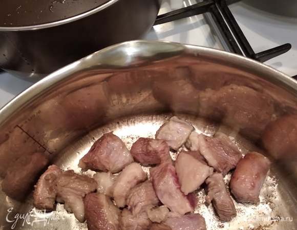 В казане или кастрюле с толстым дном, если нет казана, раскалить растительное масло и обжарить говядину до образования румяной корочки. Когда образуется корочка, можно посолить. Добавить лук, чеснок и перец чили. Если начинает пригорать, можно добавить немного горячей воды.