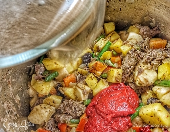 Добавляем томатную пасту и выливаем бульон. Бульон должен покрывать все наши овощи с мясом. И его должно быть больше сантиметра на 2–3.