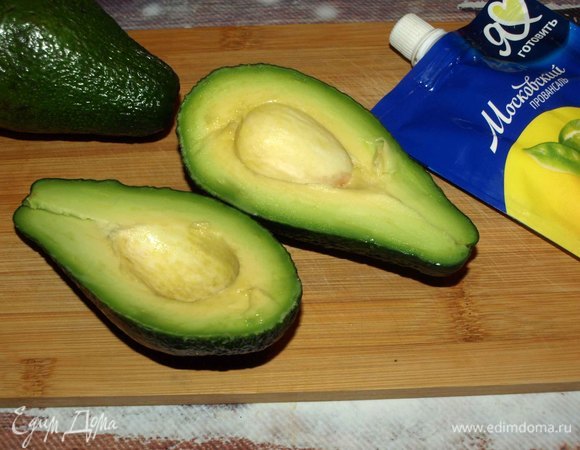 Спелые авокадо очистить, разрезать и извлечь косточку. Чайной ложкой увеличить углубление. Извлеченную мякоть мелко нарезать и добавить в салат.