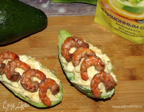 Кладем в лодочки из авокадо салат, сверху добавляем креветки.