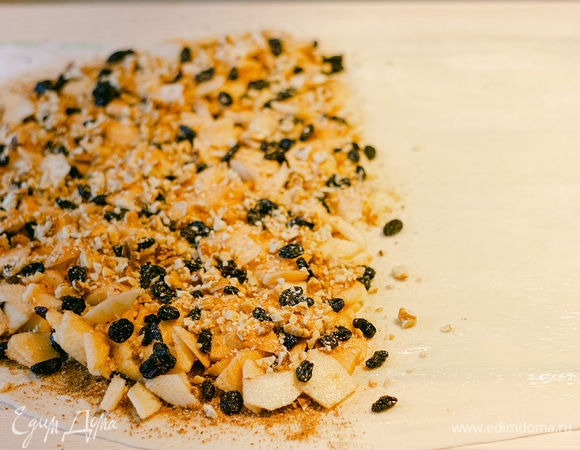 Сверху на сухари положить яблоки, посыпать сахаром, изюмом и орехами.