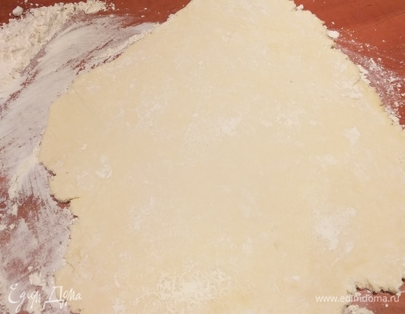 Стол хорошо посыпаем мукой. Отрезаем часть теста, раскатываем толщиной примерно 0,5 см. Оставшееся тесто убираем в холодильник.