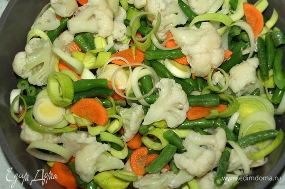 В жаропрочную посуду выкладываем стручковую фасоль, цветную капусту, лук-порей и морковь. Все перемешиваем.