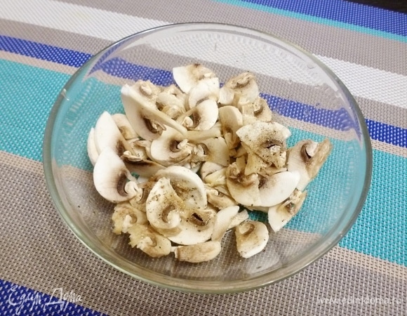 Шампиньоны нарезать пластинками. Посолить, добавить щепотку сахара и полить соком лимона. Оставить минут на 10, чтобы они слегка промариновались.