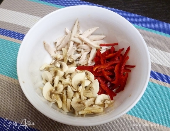 Соединить в салатнике нарезанное соломкой куриное филе, сладкий перец и шампиньоны.