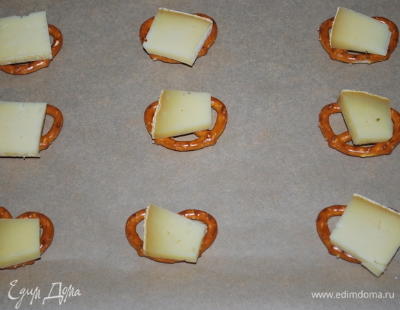 На брецели положите по кусочку сыра и поставьте запекаться в разогретую до 170°C духовку на 3–4 минуты, пока сыр не расплавится. Возьмите столько кренделей, сколько хотите приготовить закуски.