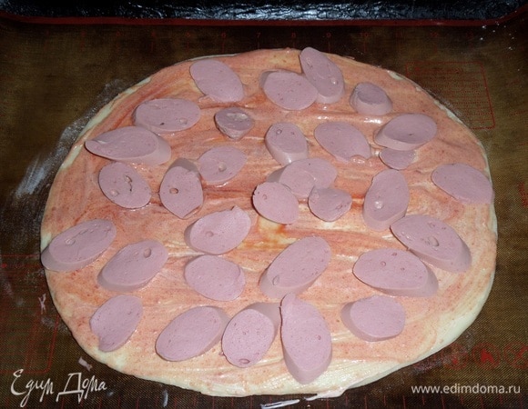 Теперь выкладываем нарезанные сосиски.