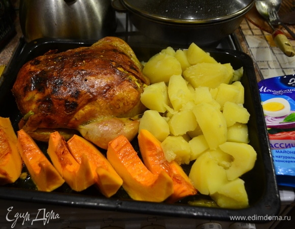 Когда курица практически готова, добавляем на противень отварную картошку и кусочки тыквы (они готовятся за 10 минут), поливаем маслом. Отправляем еще раз все в духовку минут на 15.